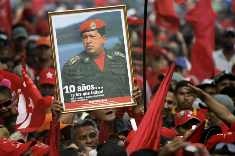 Image: A supporter holds up a portrait of Venezuela's President Hugo Chavez