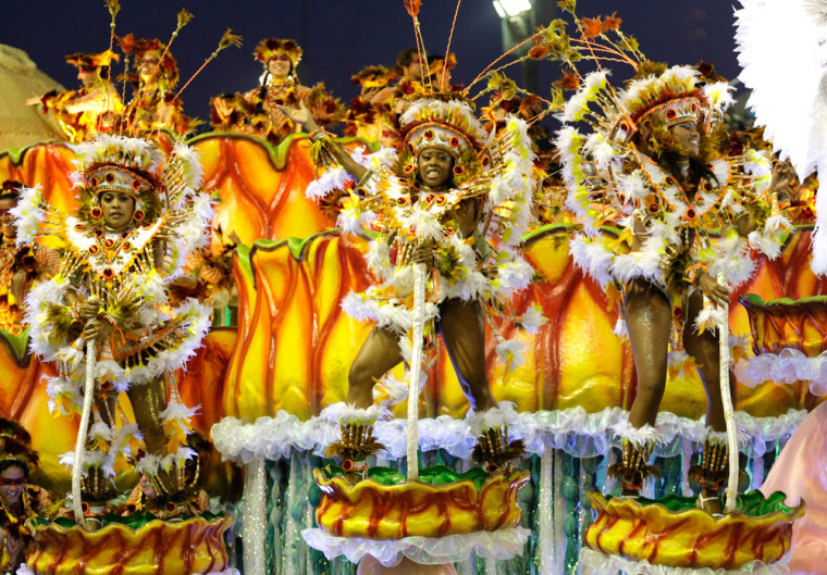 Image: Revellers of Unidas da Tijuca samba school dance atop a float during the first night of the Carnival parade in Rio de Janeiro's Sambadrome