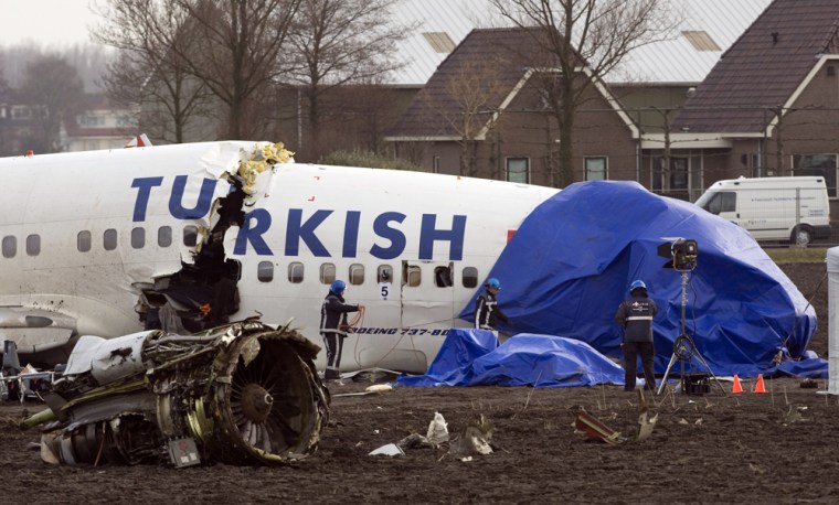 Image: Firefighters remove tarpaulins from the wreckage of the Turkish Airways jet