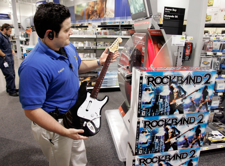 Image: A worker holds up a guitar as part of the \"Rock Band 2\"