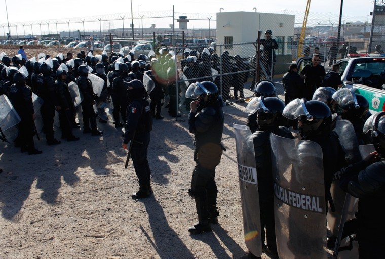 Image: Federal riot police await orders to enter to end a riot at the state prison on the outskirts of the border city of Ciudad Juarez