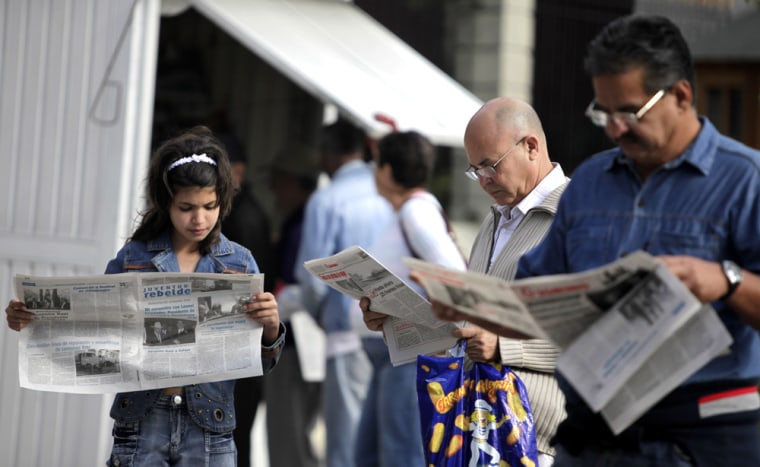 Image: People read Granma and Juventud Rebelde newspapers