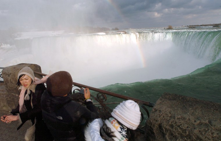 Image: Tourists look over the brink of the Horseshoe Falls at Niagara Falls, Ontario