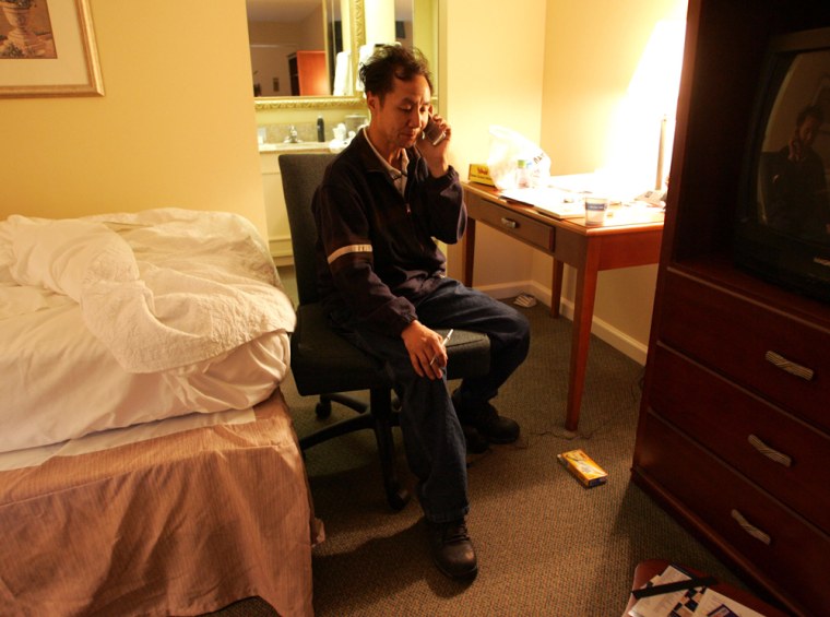 Brian Tzeo speaks on the phone inside a hotel room Monday, March 16, 2009 in Hickory, N.C.. Tzeo's wife Lisa Phan, daughters Pauline Chao, 18, Melanie Saephan, 20, and son Cody Tzeo, 3, were murdered Thursday, March 12, 2009 at their home in Conover, N.C. Authorities are still searching for the suspect and a motive. (AP Photo/Jason E. Miczek)