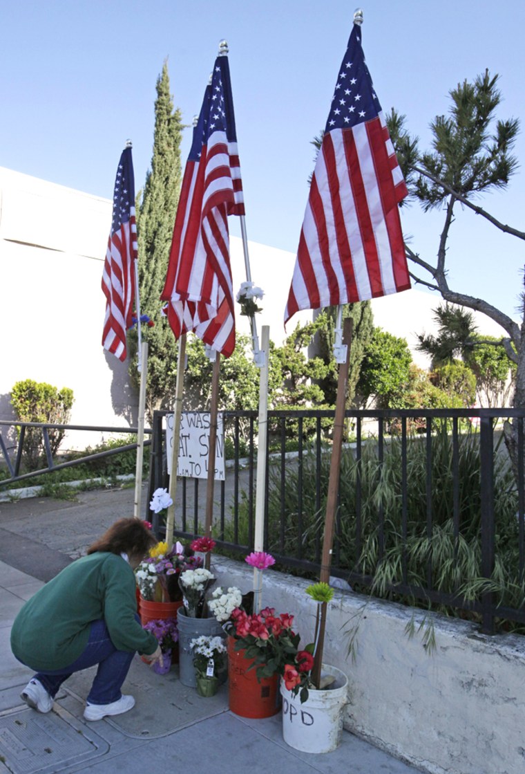 Image: Virginia Lew stops to place flowers at a memorial