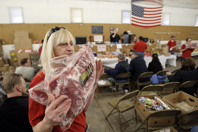 Image: Janet Cool displays frozen meet during the grocery auction