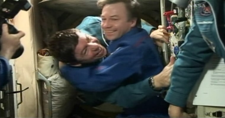 NASA astronaut Michael Barratt, left, floats into the international space station and immediately gets a greeting hug from Russian cosmonaut Yuri Lonchakov on Saturday.