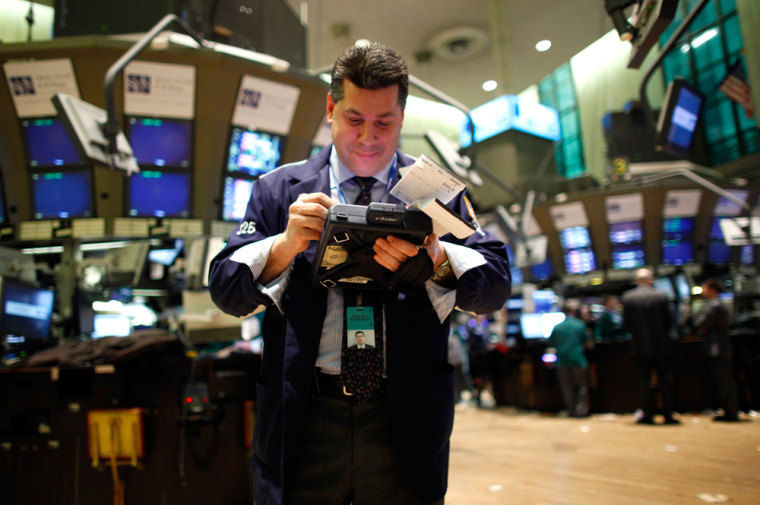 Image: A trading specialist uses his handheld computer on the floor of the New York Stock Exchange
