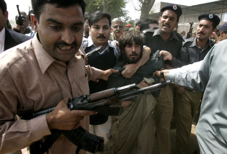 Image: Pakistani police officers arrest one of the allegedly gunmen
