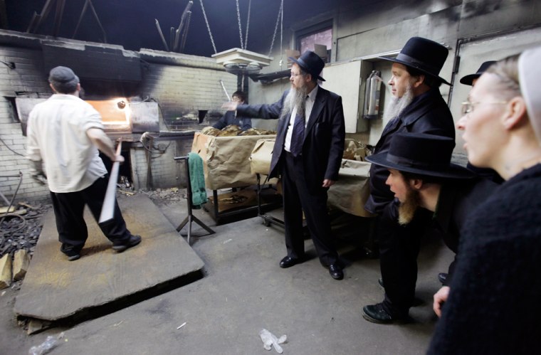 Rabbi Beryl Epstein, center, explains the process of baking matzo for Passover to a group of Pennsylvania Amish Tuesday, March 31, at a matzo factory in the Crown Heights neighborhood of Brooklyn, New York.