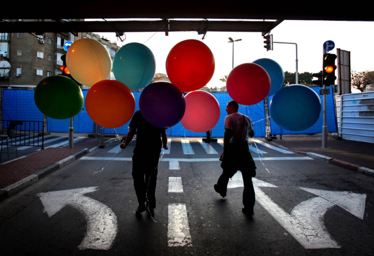 Israeli carry balloons during preparations to mark the 100th anniversary of Tel Aviv, at Rabin square in Tel Aviv, Israel, Saturday April 4, 2009. Tel Aviv the world's first purpose-built Jewish city was founded in 1909. Tel Aviv is the second-largest city in Israel. (AP Photo/Oded Balilty)