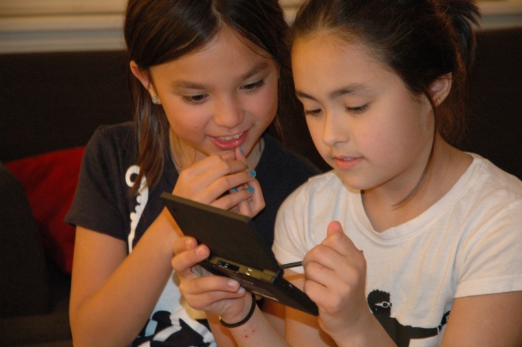 Image: Girls play on Nintendo's DSi gaming handheld