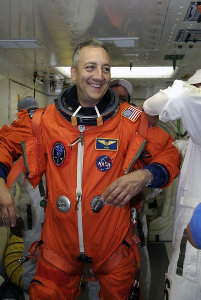 STS-125 Mission Specialist Mike Massimino is helped by a suit technician to don a harness over his launch and entry suit before entering space shuttle Atlantis for a simulated launch countdown. Credit: NASA/Amanda Diller.