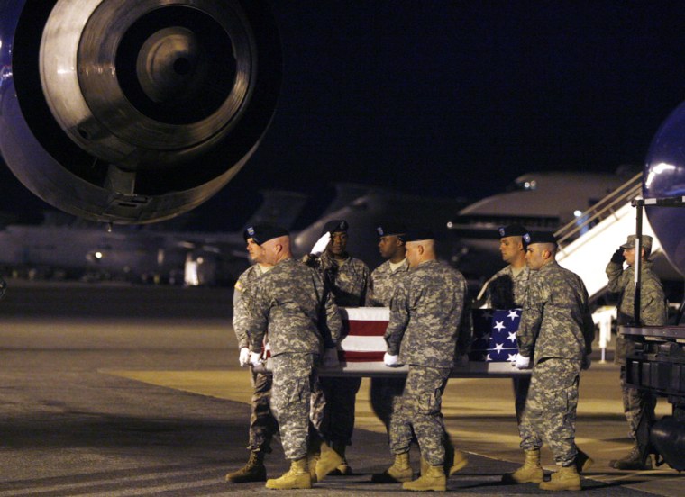 Image: A team of airmen moves the transfer case containing the body of Army corporal Pautsch
