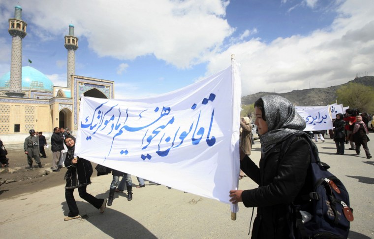 Image: Afghan Shiite women carry a banner which reads \"We want a law, but democratic one,\"