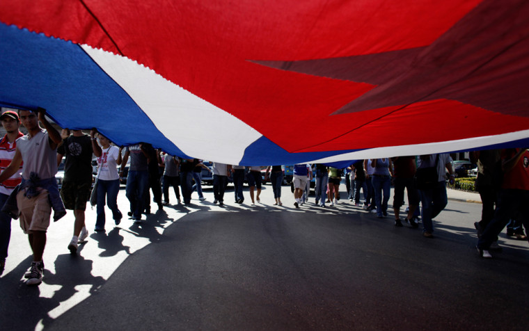 Students hold a Cuban flag during a march to mark the 48th anniversary of the triumph of Cuban forces during the  1961 Bay of Pigs invasion , in Havana, Saturday, April 18, 2009. Trading their warmest words in a half-century, the United States and Cuba built momentum toward renewed ties on Friday, with President Barack Obama declaring he \"seeks a new beginning,\" including direct talks, with the island's government.(AP Photo/Javier Galeano)
