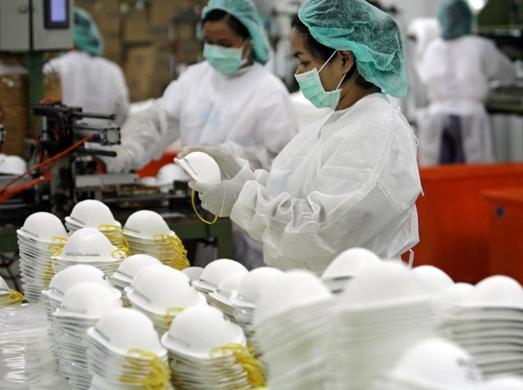 Image: A worker inspects a finishing product of a N95 face masks inside a Medtecs warehouse in Bataan province, north of Manila