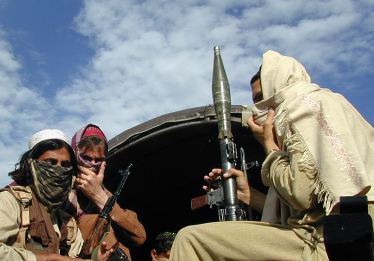 Image: Pakistani Taliban fighters sit with their weapons on the back of a truck in Buner