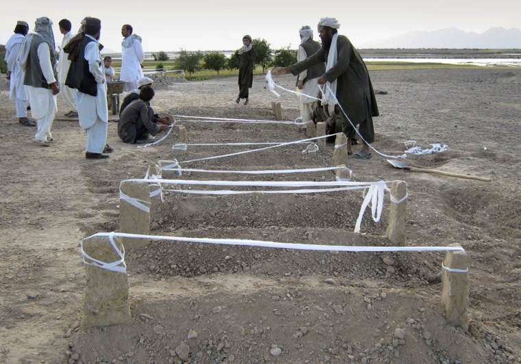Image: Afghan villagers mark new burial sites