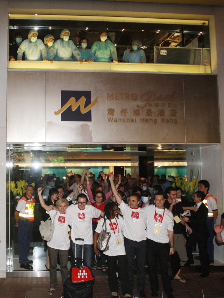 Hotel guests celebrate after being released from quarantine at the Metropark Hotel where they were held for a week in Hong Kong on Friday. Hong Kong on Friday lifted its weeklong quarantine on a downtown hotel where a Mexican swine flu patient stayed, releasing some 280 guests and employees who were isolated in the building. 