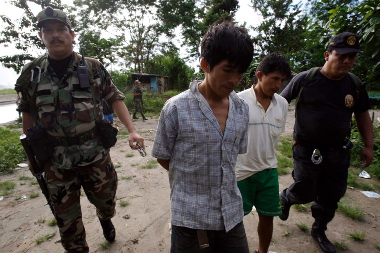 In this photo taken April 22, 2009, police escort two men after they were arrested in Puerto Cocos in Peru's Apurimac Valley.  According to police, the men were were caught with money, guns and were holding a couple hostage. Rebels from Peru's Maoist-inspired Shining Path movement have killed 33 soldiers since Peru's military mounted an offensive in August. Though they are small in number, there's no indication the guerrillas have suffered serious casualties or seen their drug smuggling disrupted. Peru is the world's No. 2 cocaine producer after Colombia. (AP Photo/Martin Mejia)