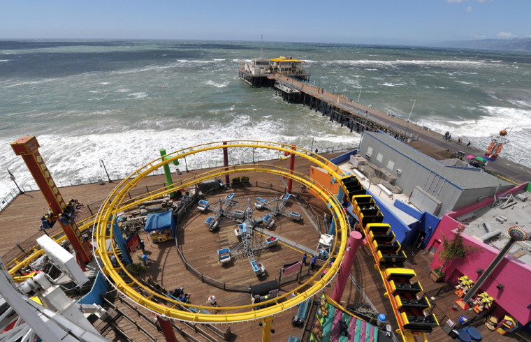 Image: People enjoy riding a roller coaster at the Pacific Park in Santa Monica Pier, California