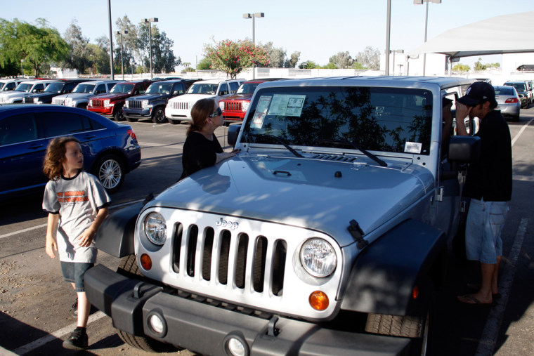 Image: David Quaranta III, Lisa Quaranta and David Quaranta II look at a Jeep vehicle at a Performance Chrysler Jeep Dodge dealership in Phoenix, Ariz.