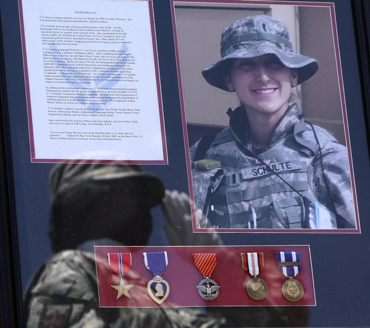 Image: A saluting U.S. soldier is reflected on a photo frame of 1st Lt. Roslyn Schulte