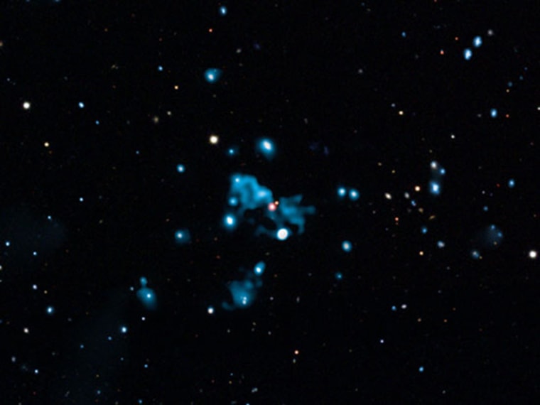 The diffuse blue object near the center of this composite image is believed to be a cosmic "ghost," called HDF 130, generated by a huge eruption from a supermassive black hole in a distant galaxy.