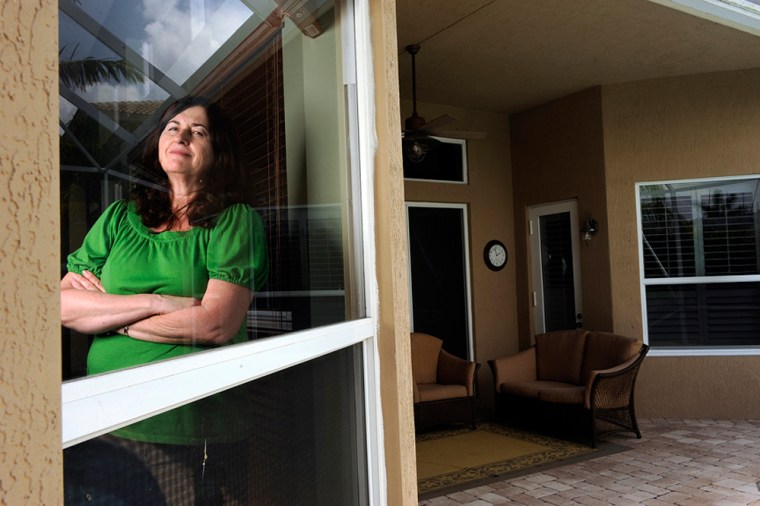 MAY 31, 2009 BOYNTON BEACH, FLA-Susan Scibetta of Boynton Beach, Fla., stands behind the new hurricane impact resistant windows at her home. Scibetta, who is affectionately called Chicken Little by her friends and family, is a perfectionist preparer when it comes to hurricane season. Her garage is stocked with 20 boxes of bottled water. She has a closet full of labeled provisions and a built-in generator. On occasion she has been known to help others decide what to buy for an upcoming storm while she is at the store buying her own provisions. PHOTO BY JOSH RITCHIE
