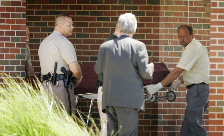 Image: The body of a shooting victim is removed from the Reformation Lutheran Church in Wichita, Kan.