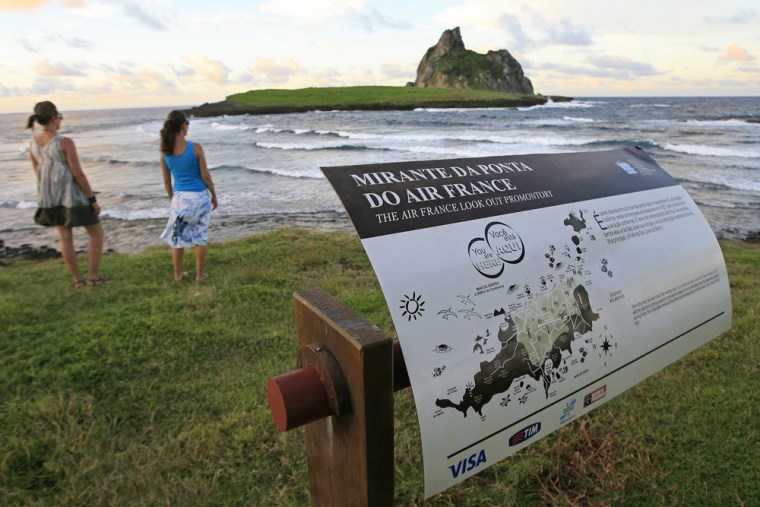 Image: Tourists walk at a lookout point near a former Air France communications base at Fernando de Noronha Island