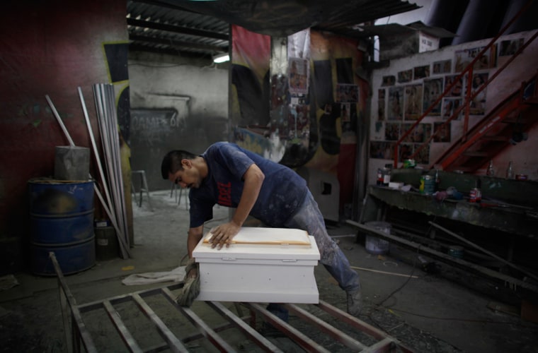 A man works on a coffin for children killed during a fire at a daycare center in Hermosillo, Mexico.