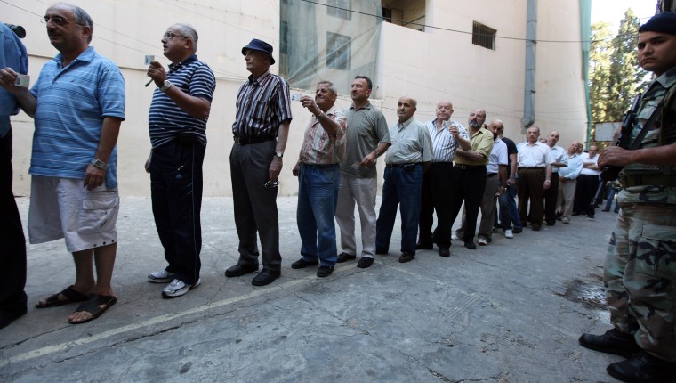 Image: Lebanese men line up at the entrance of a polling station