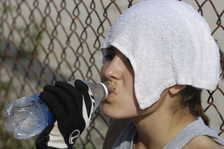 Edwardsburg's Mariah Murphy drinks water as she sits in the dugout with a wet towel on her head before the start of action at Osolo Wednesday, June 11, 2008.