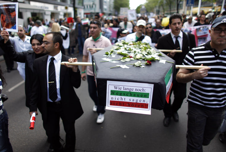 Image: Protesters carry a mock coffin and picture of a victim of violence in Tehran as they gather for a demonstration in support of the Iranian opposition in Berlin