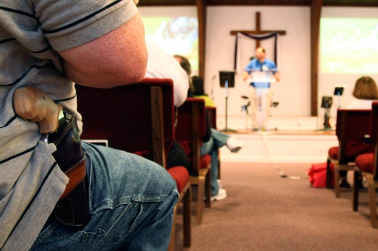 Image: A man with firearm listens to pastor Ken Pagano at the New Bethel Church in Louisville