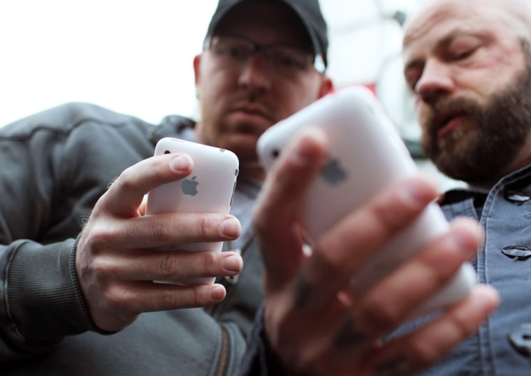 Image: Two men holding iPhones
