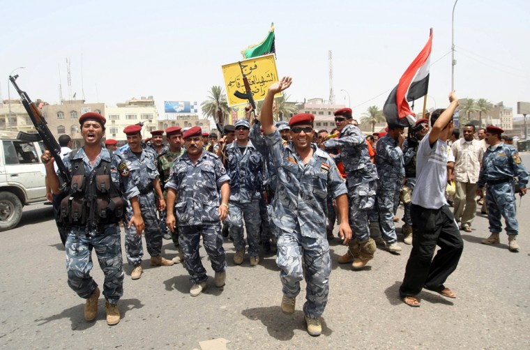 Image: Iraqis police and soldiers celebrate on the streets of the southern city of Basra