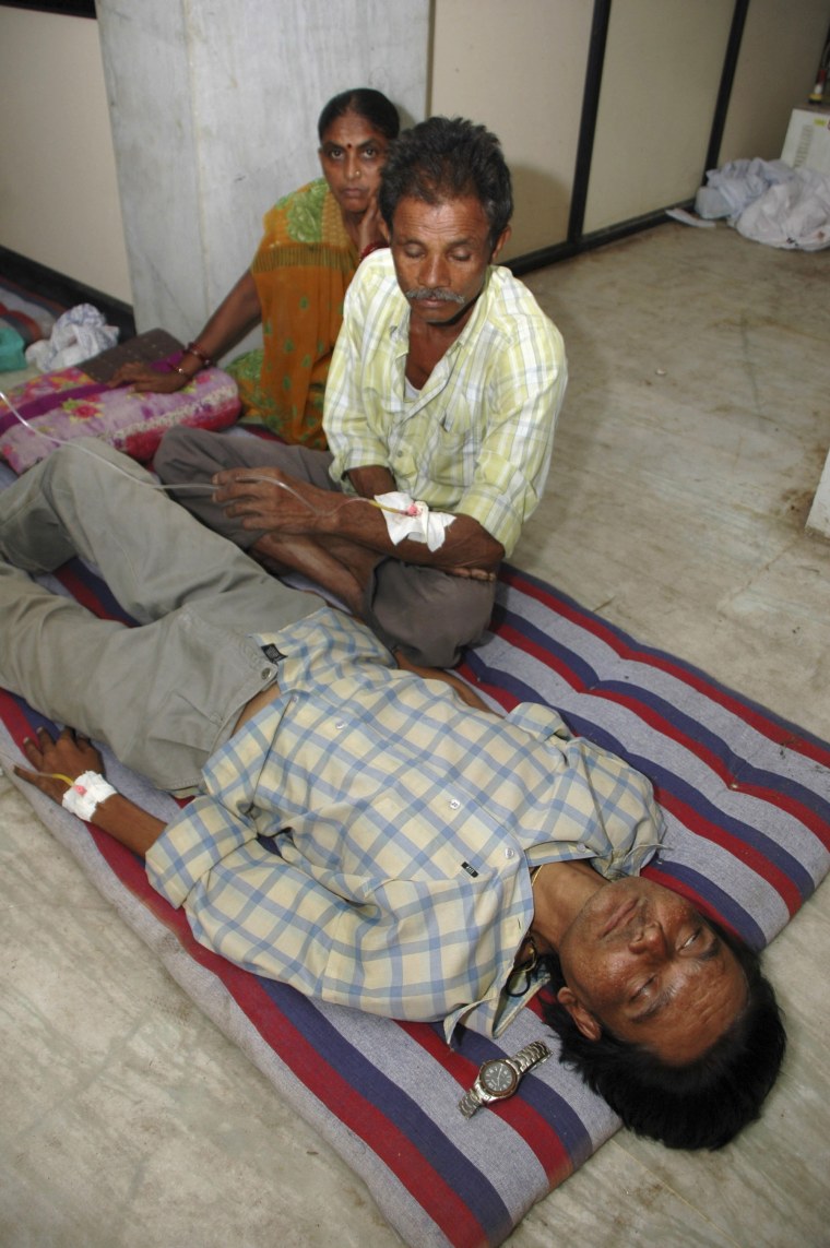 Image: A person who consumed illicitly brewed liquor awaits treatment at a hospital