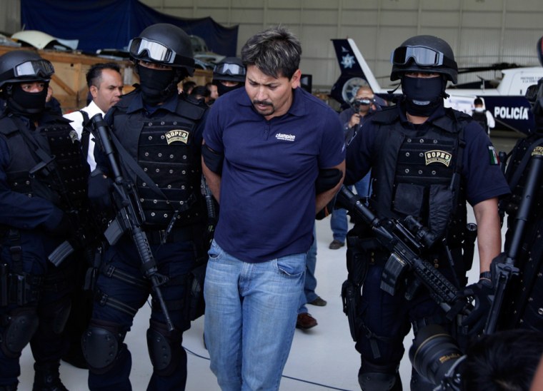 Image: Police escort Arnoldo Rueda, an alleged coordinator for the Mexican drug cartel known as, \"La Familia\"