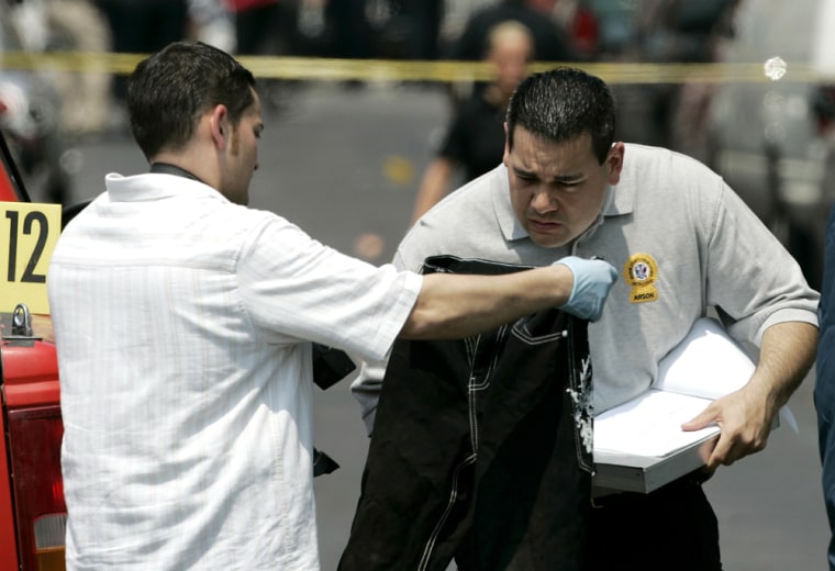 Image: Detectives investigate the scene of a shootout