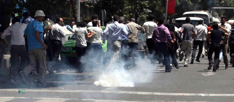 Image: Protesters run from tear gas in Tehran