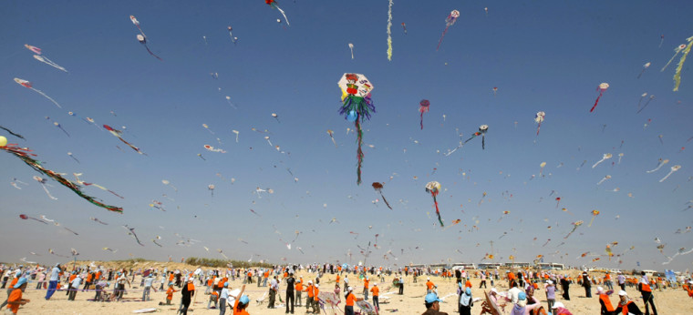 Image: People flying kites on a beach