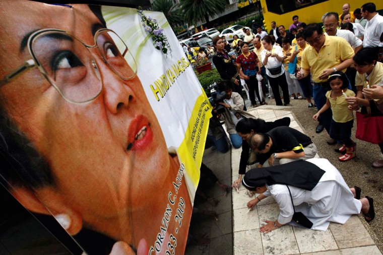 Image: Filipinos offer candles as pay tribute to  former Philippines president Corazon Aquino