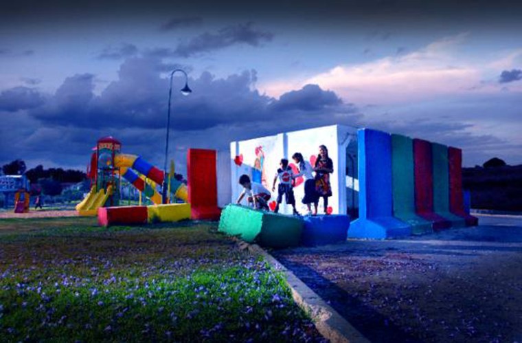 Image: Children in Sderot play on a playground with a bomb shelter on site.