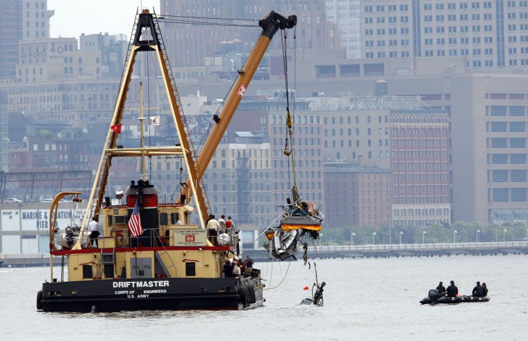 Image: Heavy lifting ship from U.S. Army Corps of Engineers lifts fuselage of helicopter from location of crash at Hudson River, in New York