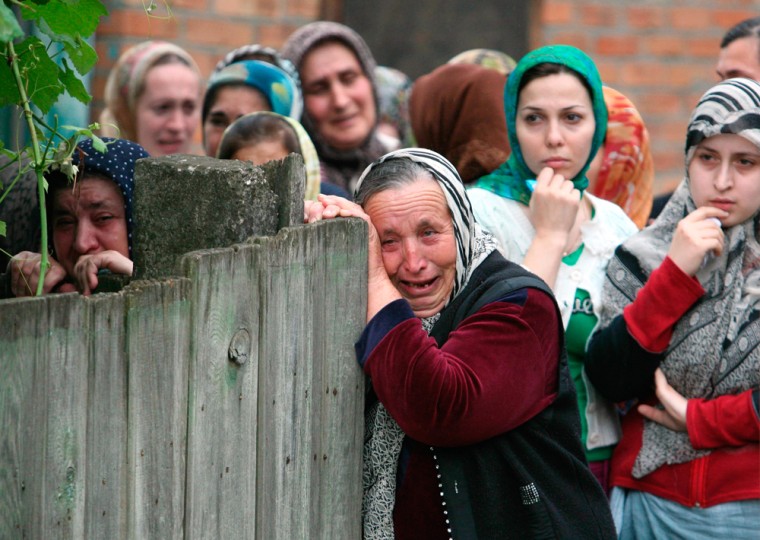 Image: Women grieve during the burial of Zarema Sadulayeva