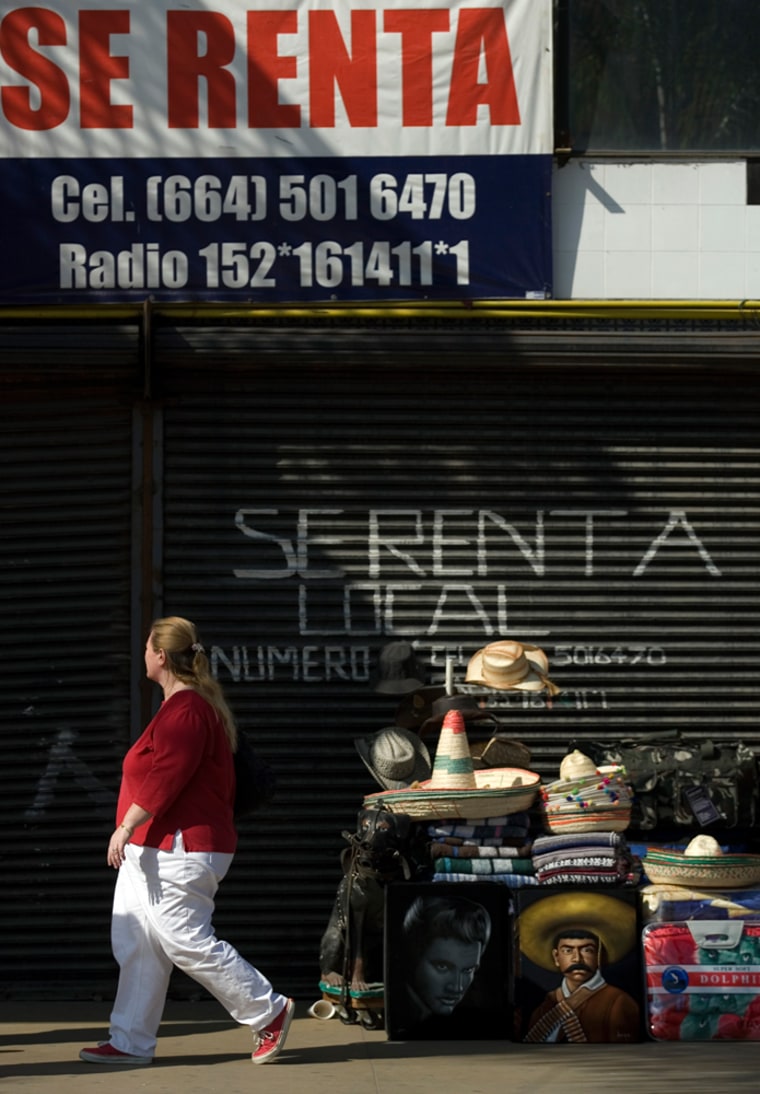 Image: Souvenirs sit for sale in front of a closed shop with a for rent sign along the famous Revolucion Avenue in Tijuana, Mexico