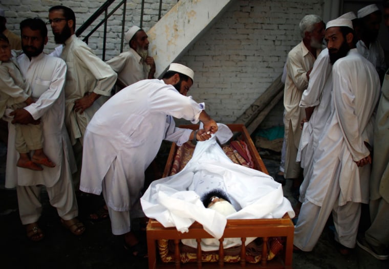 Image: amily members preparing to bury the body of alleged Taliban militant